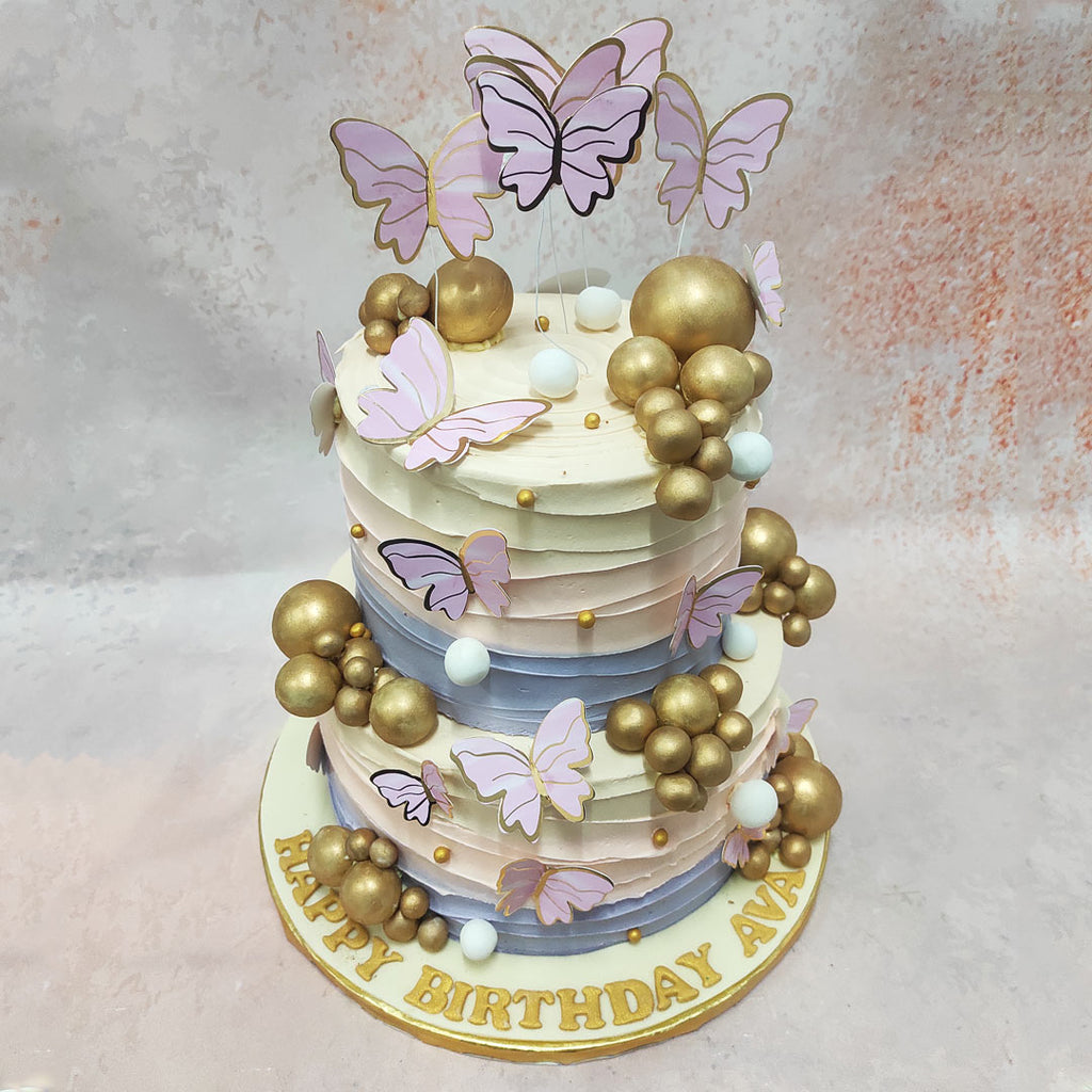 The dance of wavy, pastel buttercream cascading down this pastel butterfly cake is set in purple, pink and white