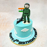 Floating amidst fluffy white clouds, a mighty fighter jet takes centre stage on this Fighter Pilot Cake, flanked by a courageous fighter pilot and the proud flag of India. 