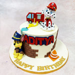 The Paw Patrol Firetruck Cake showcases impressive attention to detail with miniature accessories that bring the rescue theme to life—a tiny red fire engine, yellow fire hose, and orange traffic cone all contribute to the playful emergency services storyline. 
