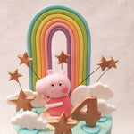 As your eyes travel upwards, you'll be greeted by Peppa herself, standing proudly in front of a magnificent rainbow on top of this Peppa and fam cake. 