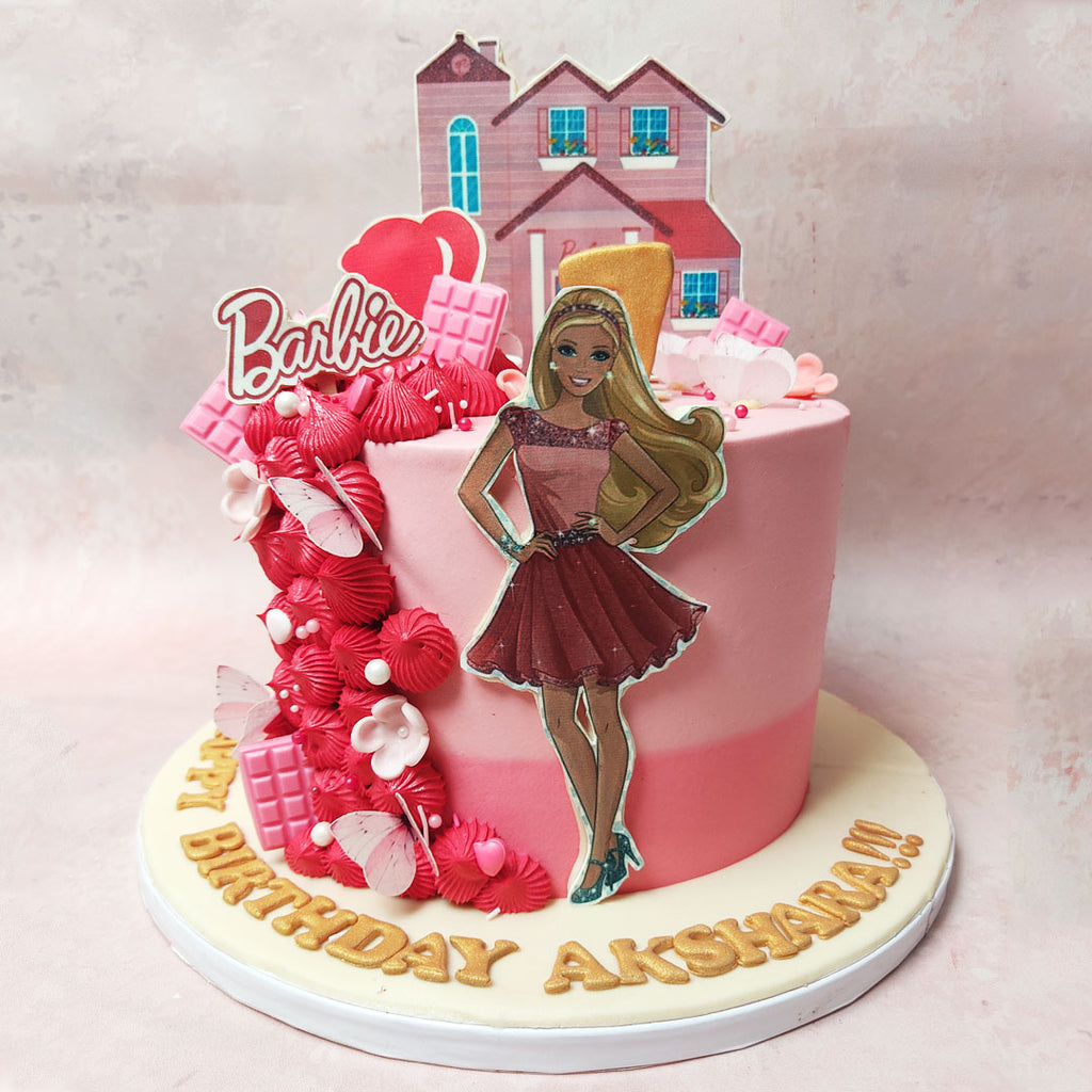 Ornamenting this Barbie House Cake, a lifelike Barbie figurine, dressed in sparkling pink, takes centre stage, inviting all to a celebration of elegance and fun. 