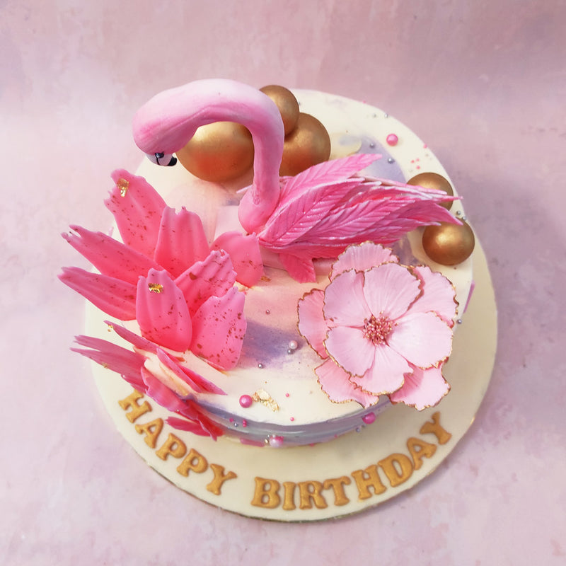 The edible flamingo's head on this Flamingo theme cake is moulded very realistically and emerges out of the creamt, textured base which represents its body. The gold baubles on this piece further complement the elegant aesthetic.