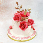 The smooth pale pink base serves as a perfect canvas for the exquisite floral arrangement that cascades across the top of this Pink Floral Cake. 