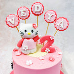 The soft pastel pink base of the Pink Hello Kitty Cake is decorated with dainty flowers, each meticulously crafted to add a touch of whimsy and playfulness, while the smooth finish of the icing provides a polished look. 