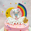 Floating atop a bed of whipped cloud puffs, the star of this Pink Kitty Cake sits sweetly with a tiny floral bow, pearl necklace, and the daintiest smile, surrounded by a golden crescent moon, a bold rainbow arc, and fluttering hearts on wires that seem to dance in mid-air.