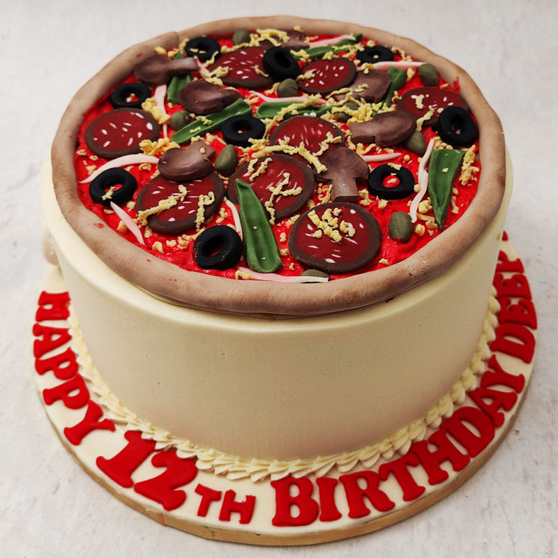A beautiful, regular crusted, medium sized pizza can be seen on this cake shaped like pizza with olives, pepperoni, mushrooms, capsicum, cheese and all your favourite toppings, but guess what? It's entirely made of cake!