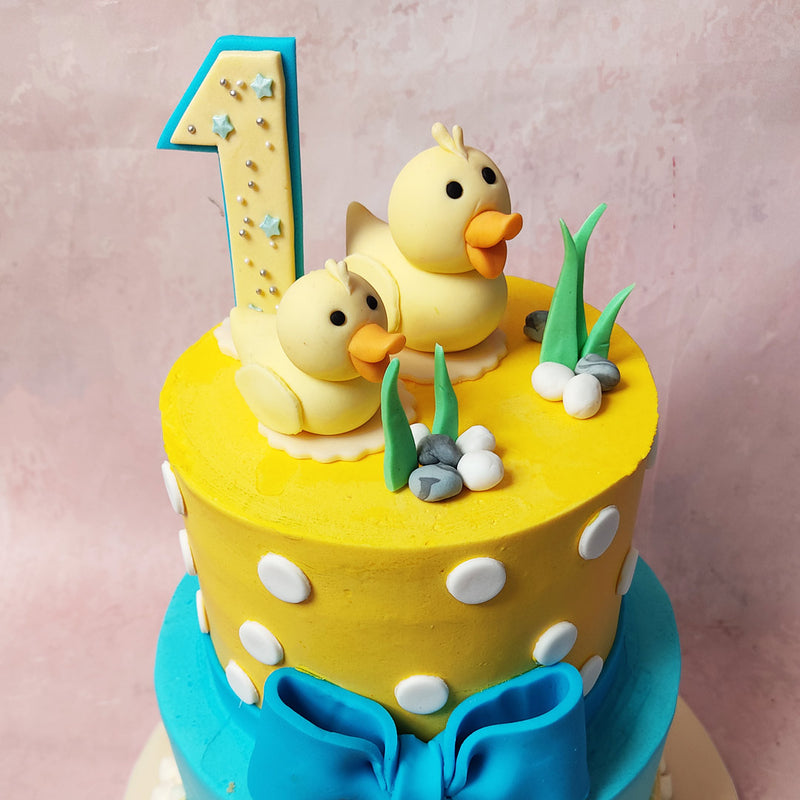 The upper tier of this Polka Dot Cake, in cheerful yellow, features a playful pattern of white polkadots, creating a whimsical ambiance.