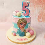 Adorned with delicate white and pink chocolate spheres, this Princess Elsa Cake is crowned with a flurry of edible snowflakes, evoking the magical world of Arendelle.