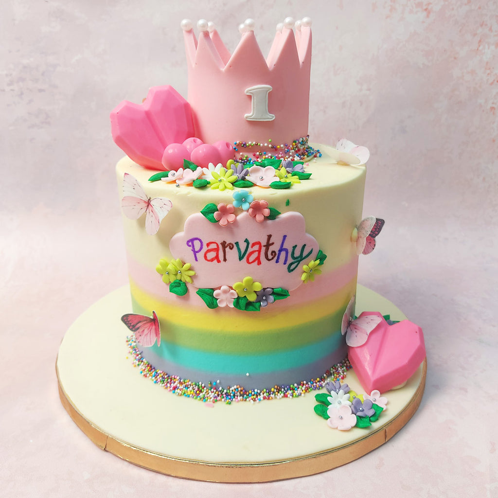 The towering masterpiece that is this Princess Garden Cake boasts a creamy base adorned with a vibrant rainbow swirl at the bottom, evoking the joy of a sunny day. 