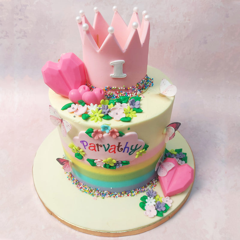 Realistic but edible butterflies, delicate edible flowers and sprinkles cascade down like confetti, transforming this Princess Rainbow Cake into a whimsical garden of delights. 
