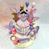 The charming figurine of a little girl perched on top of this Purple Rainbow Cake With Butterflies, dressed in a ruffled pink skirt and adorable ballet shoes, adds a personal touch, capturing the innocence and joy of a first birthday. 