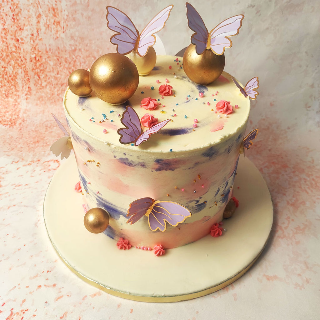 This enchanting Purple and Gold Butterfly Cake, adorned with ethereal butterflies and elegant golden spheres, is a true work of art. 