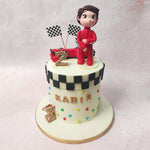Beside this Racer Cake, a young boy, dressed in a sports car suit, stands ready to embark on an adventure of speed and thrills.