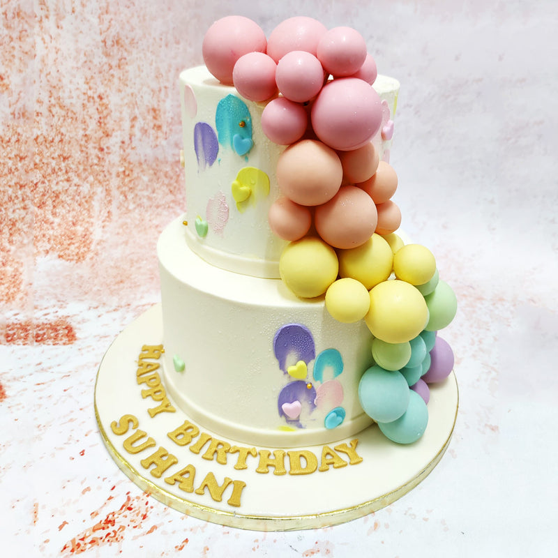 The colours of the balloons range from soft pinks to gentle blues and yellows, creating a harmonious and visually appealing palette on this Rainbow Balloon Cake.