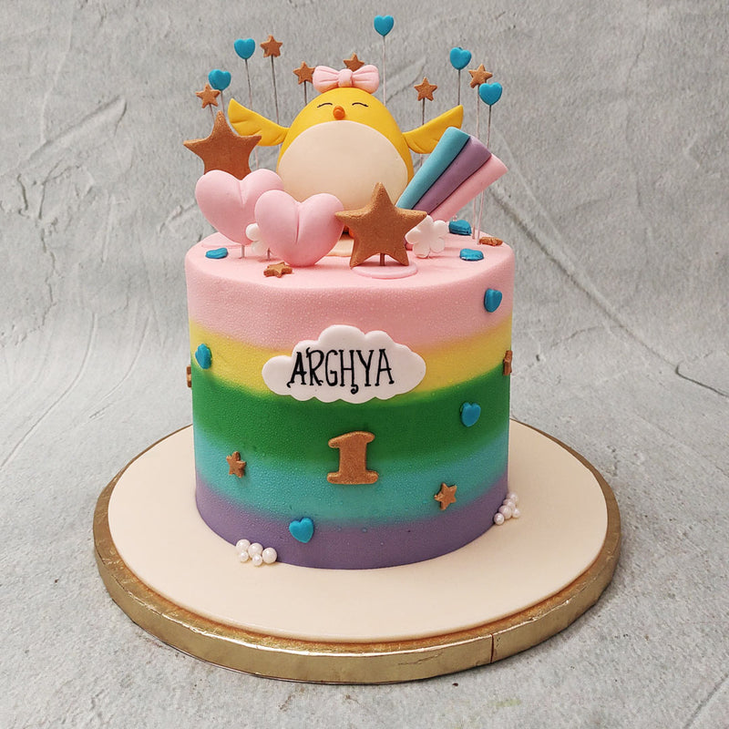 With a rainbow base, ornamented with stars and hearts, this rainbow chick cake takes on somewhat of a celestial theme.