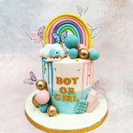 The pristine backdrop of this Rainbow Drip Baby Shower Cake is artfully adorned with contrasting drips of soft blue and delicate pink, symbolising the age-old question that brings loved ones together in joyful speculation.
