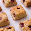 Close-up of Raspberry Financiers showing the moist, rich texture and golden topping of slivered almonds and baked raspberries.