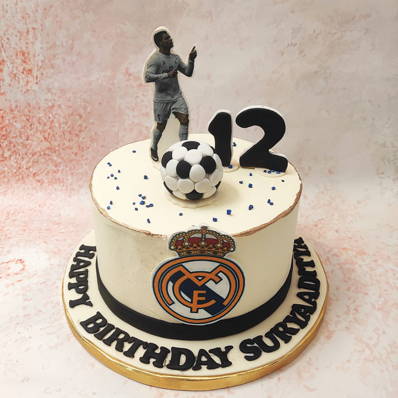 Topped with a detailed figure of a football player mid-celebration, this Madrid Birthday Cake brings the excitement of a match day to your special occasion. 