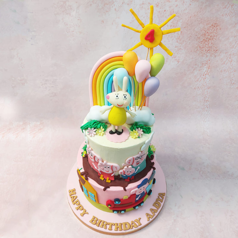 Atop the cream-coloured top tier of this Peppa Pig Rainbow Cake, Peppa and her beloved family bask in the warmth of the sun, surrounded by fields of cheerful flowers and inviting mud puddles. 