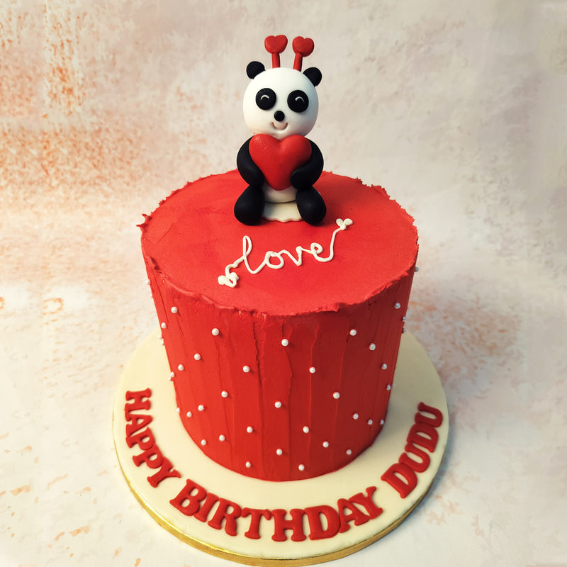 Adorned in a striking red hue, this charming Red Panda Cake features a delightful panda topper, clasping a heart with pure affection. 