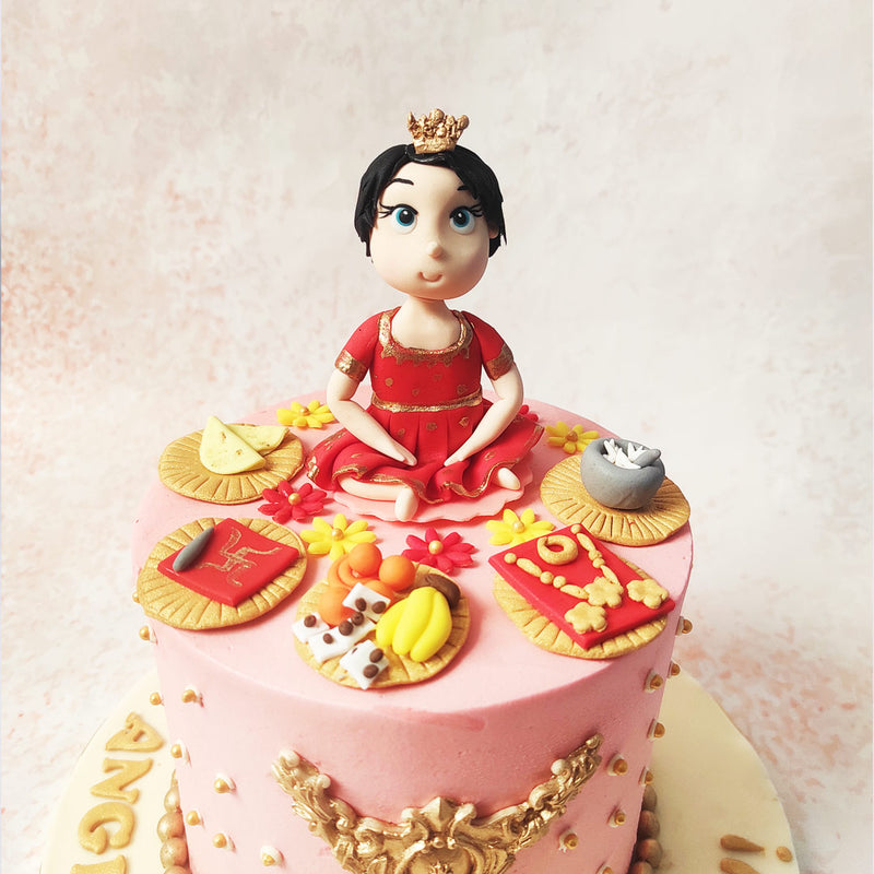 The little one is seated amidst an array of miniature food items atop this Rice Ceremony Cake, symbolising the abundance and blessings associated with the Annaprashana ritual. 