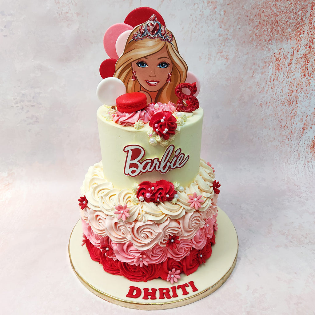 Above, the top tier of this Red and White Barbie Cake elegantly with a simple cream-coloured base, proudly displaying the iconic Barbie logo or text at its centre, completing the look of a chic mini dress. 