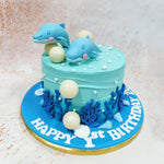 This Sea Themed Cake features a serene aqua-blue buttercream exterior that perfectly mimics the tranquil waters of tropical seas, complete with subtle wave-like texturing that creates movement across its surface. 