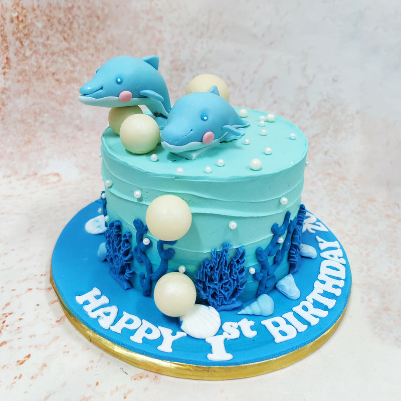 This Sea Themed Cake features a serene aqua-blue buttercream exterior that perfectly mimics the tranquil waters of tropical seas, complete with subtle wave-like texturing that creates movement across its surface. 