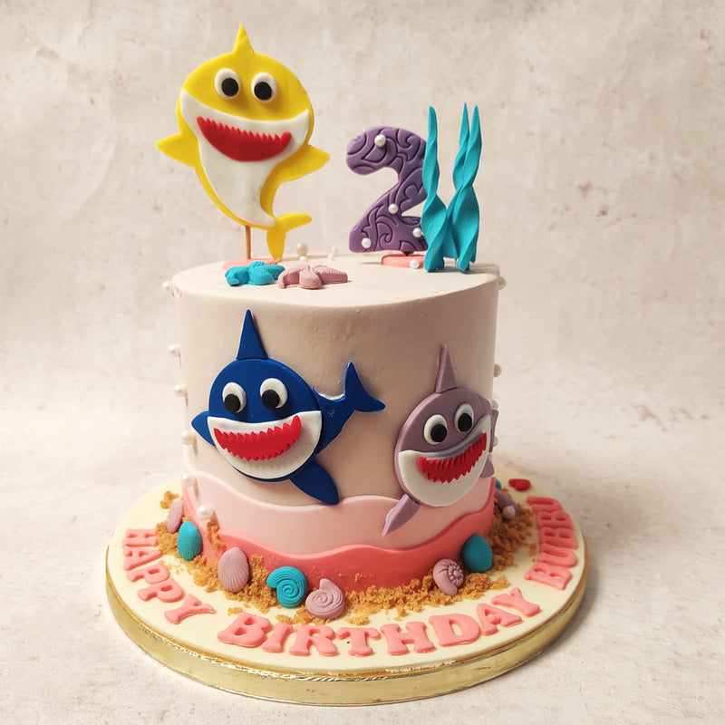 The gentle hue of this Pink Baby Shark Cake whispers tales of serene ocean sunrises, setting a tranquil stage for the excitement that lies ahead.