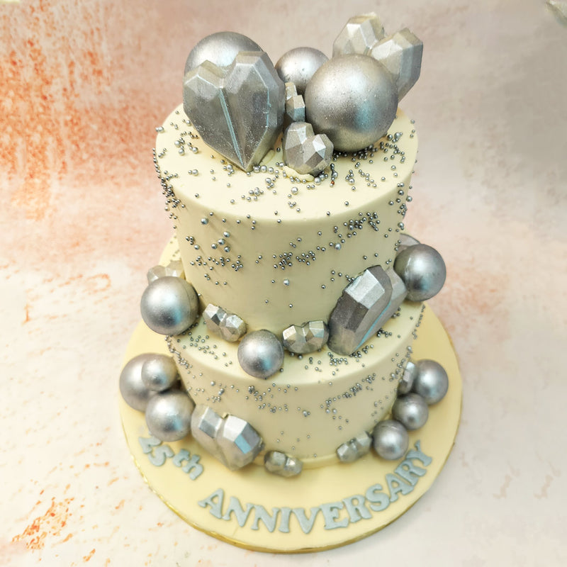 The pristine white icing on this Silver Hearts Cake serves as the perfect canvas for the striking silver accents that adorn it. 