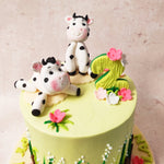 And atop this animal theme cake design, two adorable cows were lazily grazing, their sweet faces bringing a smile to anyone who gazed upon them.