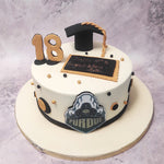 This heartwarming graduation ceremony cake features a white base adorned with elegant black and gold ornamentation, symbolising the journey of knowledge and success.
