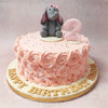 Encircling the nostalgic panorama of this Elephant Cake is a rosette pattern of pink buttercream, each swirl meticulously piped to perfection, embodying the delicate whorls of a blooming garden.