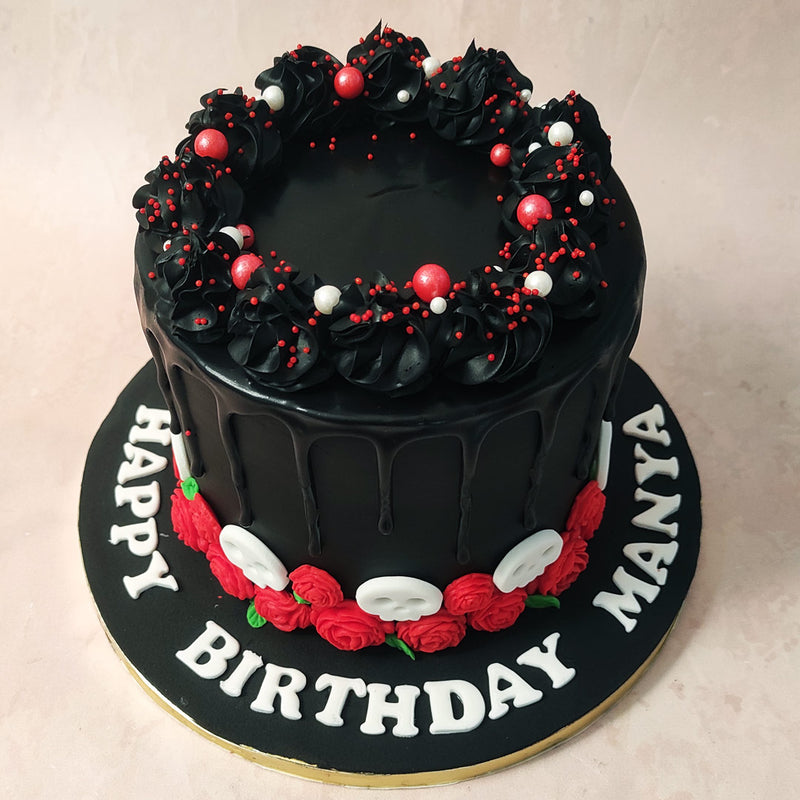 Rich buttercream swirls embellish the top of this chocolate drip cake, covered with red and white sprinkles which add to the festive and celebratory aesthetic of this design.