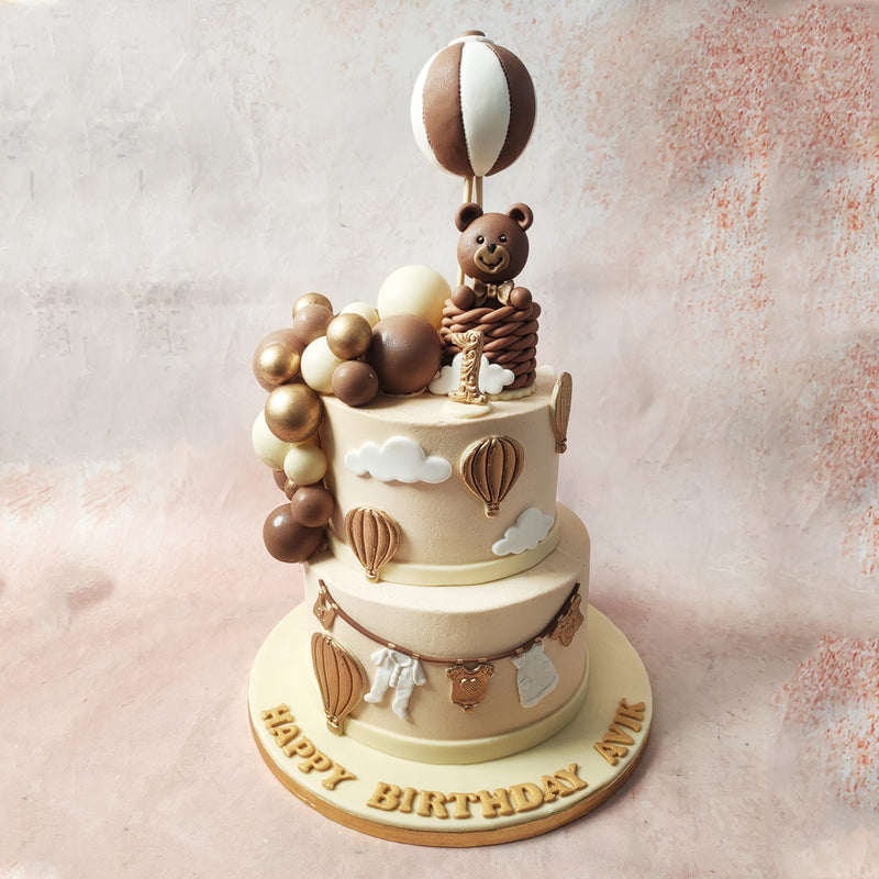 Shift your gaze to the top tier of this Soft Toy Cake, where fluffy white clouds form a celestial playground for a brown and white hot air balloon from where, a joyous teddy bear peeks out