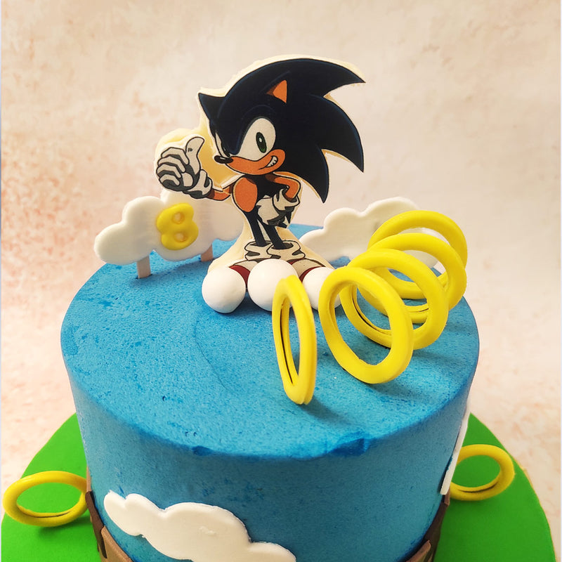 The centrepiece of this delightful Sonic Birthday Cake is a meticulously crafted figure of Sonic the Hedgehog himself, surrounded by the iconic golden rings