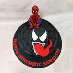 This Spiderman and Venom Birthday Cake features a sleek black fondant exterior meticulously embossed with an intricate spiderweb pattern that radiates outward, capturing the iconic imagery associated with the beloved superhero. 