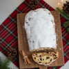 Whole Stollen Bread loaf dusted heavily with powdered sugar and sliced, showing the marzipan filling, dried fruit, and nuts.