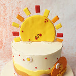 Beneath the sun, this scenic cake is adorned with playful polka dots and delicate daisies, each adding a touch of whimsy and charm to the overall presentation.