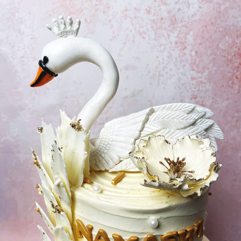 The tiers of this Feather Cake are decorated with sophisticated white chocolate feathers, delicately arranged to mimic the swan’s plumage, adding a touch of ethereal charm. 