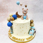 The magical atmosphere of this Teddy Theme Celestial Cake is enhanced by floating balloon spheres in harmonious shades of blue, cream, and gold, creating a dreamy constellation around a golden crescent moon. 