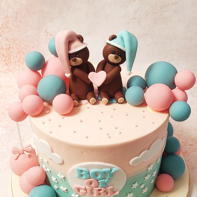 This Teddy Heart Cake is embellished with a delightful array of pastel blue and pink edible balls, adding a playful and festive touch. 