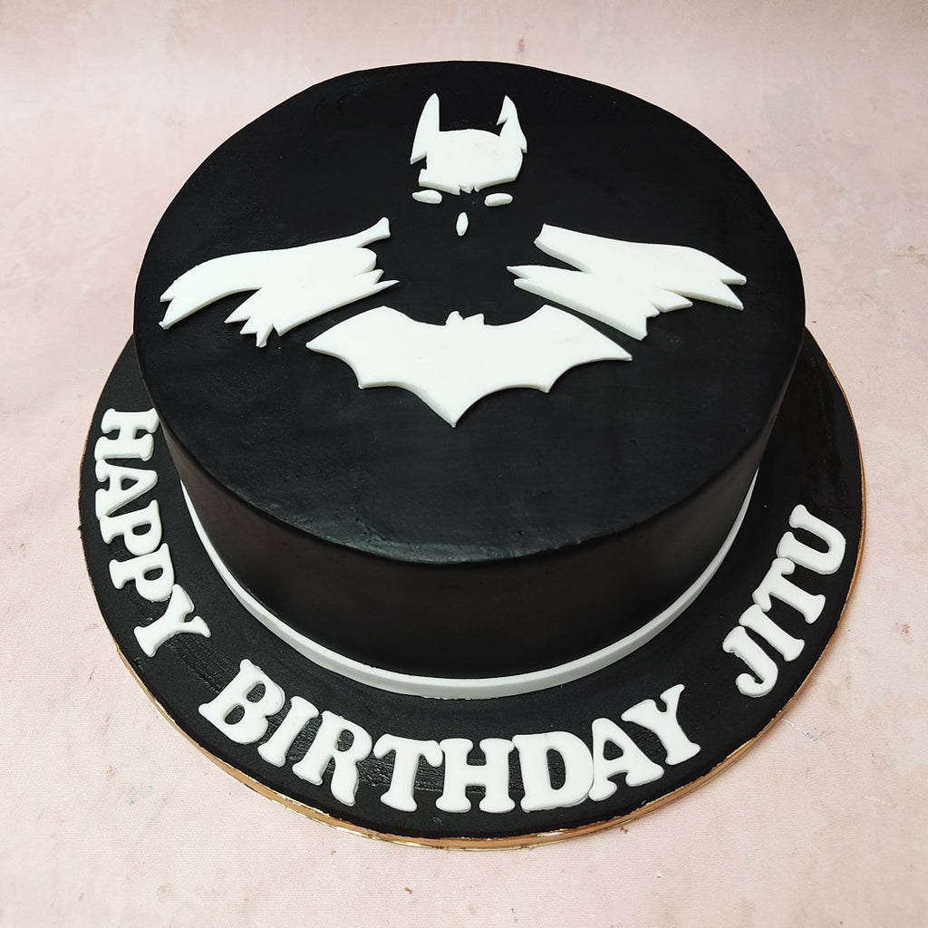 An enigmatic white silhouette emerges against the deep black tones, capturing the essence of the Dark Knight in a minimalistBlack and White Batman Cake, mirroring the mysterious allure of the series.