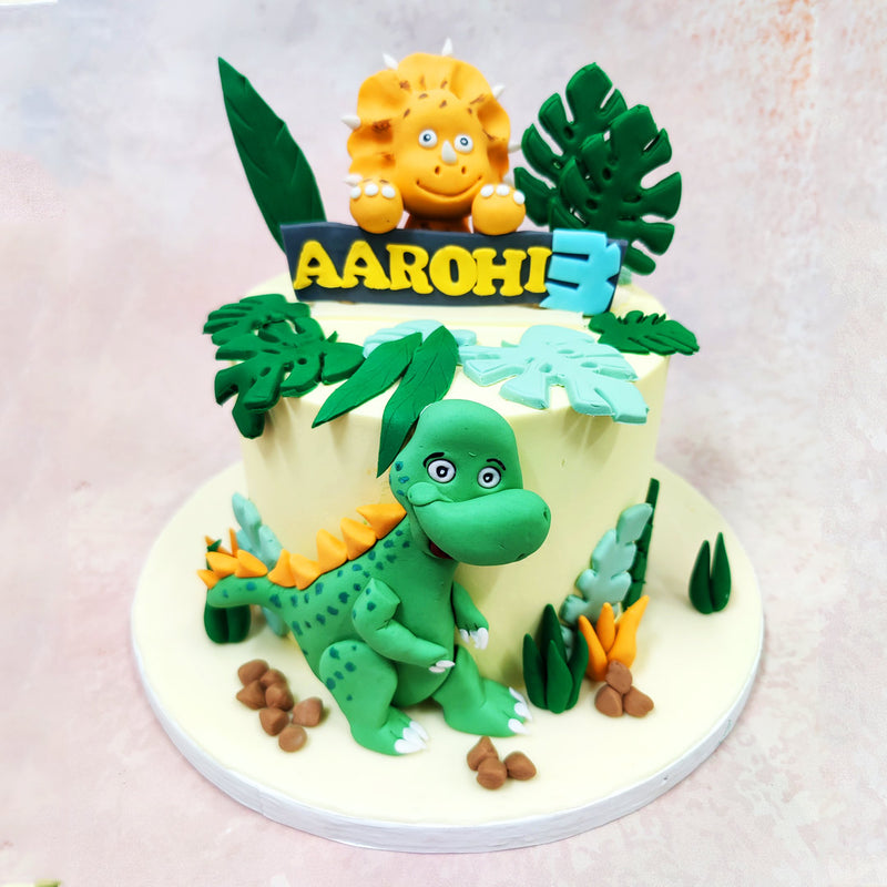 The exterior of this The Land Before Time Dinosaur Cake is a soft cream base, acting as the perfect neutral backdrop for the jungle foliage and animated characters to pop. 