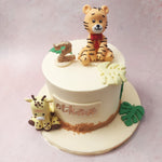 Featuring a plain white base, cookie crumbed on the bottom and with a caricature-like figurine of a tiger in top and a giraffe below, this giraffe cake has a playful aesthetic that's rooted in simplicity and minimalism.