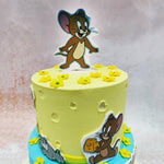 The playful elements, such as the cheese wedges and tiny flowers scattered across this Tom and Jerry Cartoon Cake, add layers of charm and nostalgia. 