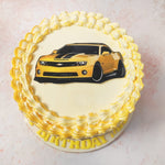 The top of this Birthday Cake For Kids showcases Bumblebee’s car form, detailed to perfection, set against a creamy backdrop with a delicate piped border, adding an extra touch of elegance.