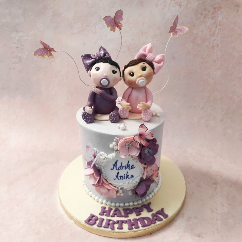 Like balloons at a party, edible butterflies can be spotted hovering around this twins cake with their strings attached to the top. 