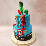 The Hulk figurine on top of this two tier Avengers cake is accompanied by his green first seemingly busting out of the top.