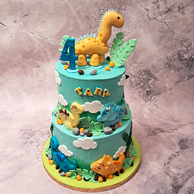 But what truly brings this two tier jurassic cake to life are the figurines of various types of dinosaurs on it.